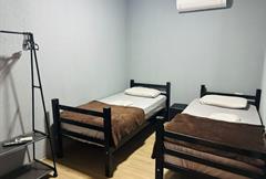 Quarto solteiro com 2 camas e banheiro comparilhado