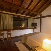 Bangalô com mezanino com uma cama king size e um sofá leito