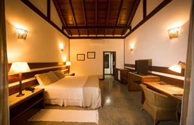 Bangalô com vista para o jardim com uma cama king size do Bupitanga Hotel